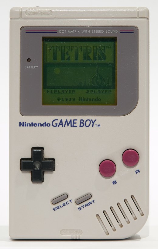An original Game Boy switched on and showing the Tetris title screen, with 1 PLAYER and 2 PLAYER options.
