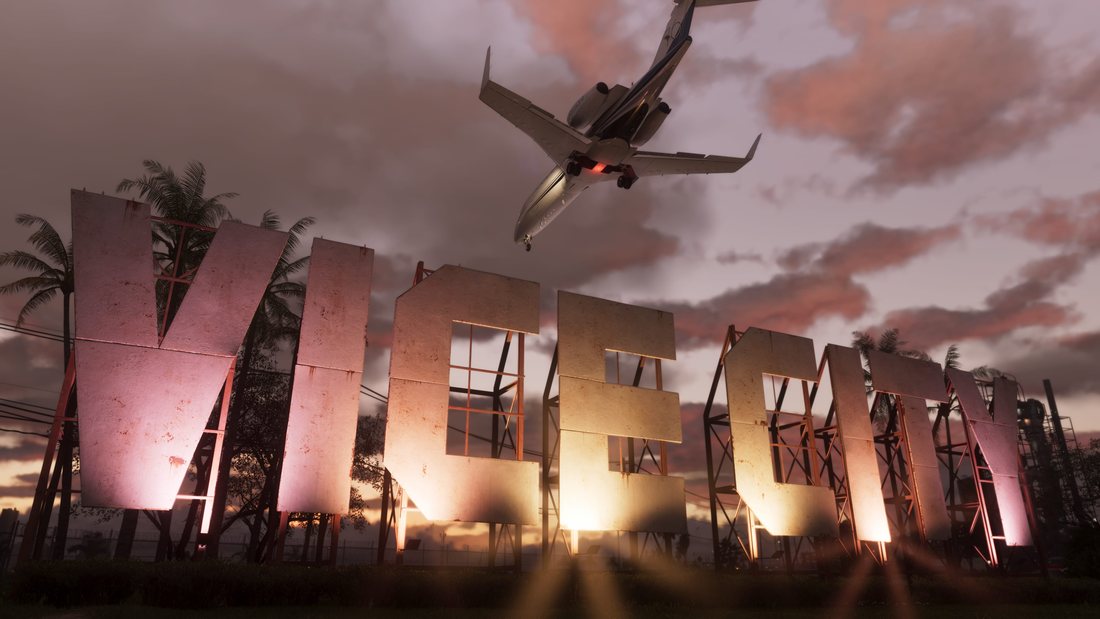 A weathered VICE CITY sign standing in front of palm trees at sunset, with a private jet passing low overhead.