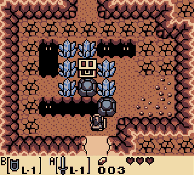 A cave interior in Link's Awakening DX: Link stands below two boulders and a treasure chest surrounded by blue crystals, with dark pits either side.