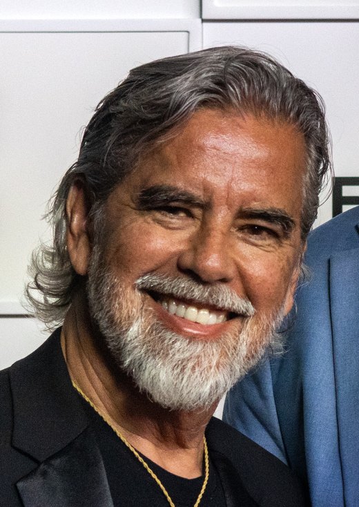 Henk Rogers, grey-haired and bearded, smiling in a dark jacket.