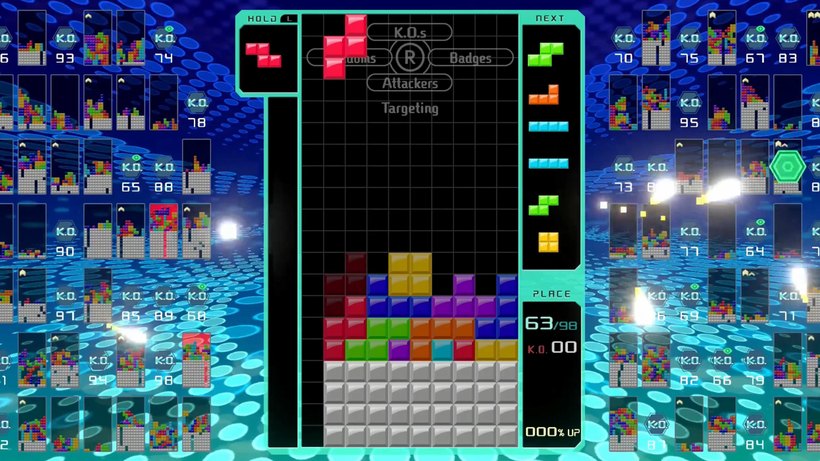 Tetris 99 on Switch: a central playfield surrounded by dozens of tiny opponent boards, with a place counter reading 63 of 98.