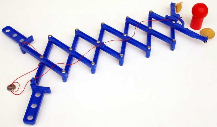 The Nintendo Ultra Hand: a blue plastic cross-lattice extending arm with yellow gripping pads at one end and handles at the other.